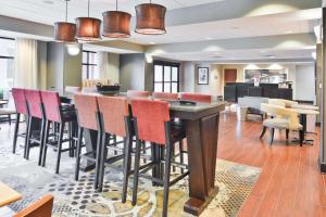 a bar in a room with chairs and tables at Hampton Inn Gonzales in Gonzales