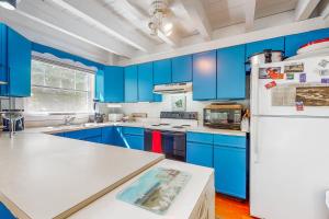 uma cozinha com armários azuis e um frigorífico branco em Martha's Hideaway em Edgartown