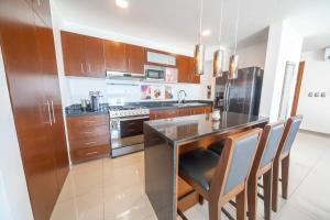 カンクンにあるStylish Three-Bedroom Condo w/Poolのキッチン(木製キャビネット、黒いカウンタートップ付) +15枚の写真