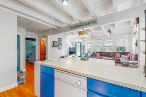 uma cozinha com armários azuis e brancos e uma sala de estar em Martha's Hideaway em Edgartown