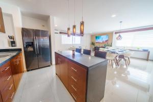 カンクンにあるStylish Three-Bedroom Condo w/Poolのキッチン(ステンレス製の冷蔵庫付)、ダイニングルーム