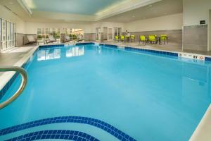 Hampton Inn & Suites - Buffalo Airport في تشيكتاواغا: مسبح كبير مع ماء أزرق في غرفة الفندق