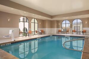 a pool in a hotel room with tables and chairs at Hampton Inn Brigham City in Brigham City