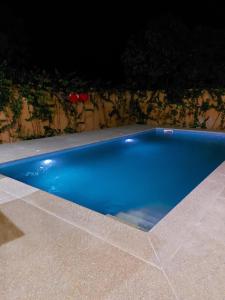 a blue swimming pool in a backyard at night at Villa Somone 4 chambres avec Piscine in Somone