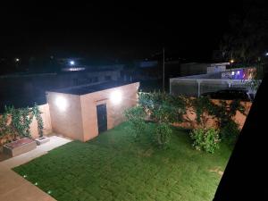 una pequeña casa con un patio por la noche en Villa Somone 4 chambres avec Piscine, en Somone