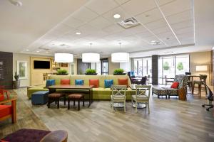 欧佩莱卡Home2 Suites By Hilton Opelika Auburn的大厅里有一张沙发、一张桌子和几把椅子