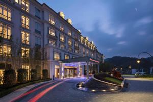 un grand bâtiment avec une rue en face dans l'établissement Hilton Garden Inn Hangzhou Lu'Niao, à Anji