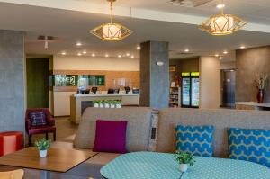 a lobby with a waiting area with a table and chairs at Home2 Suites By Hilton Atlanta Camp Creek Parkway, Ga in Atlanta