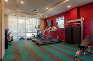 a gym with cardio equipment in a room with red walls at Home2 Suites By Hilton Atlanta Camp Creek Parkway, Ga in Atlanta