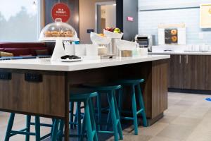 a kitchen with a counter with blue stools at Tru By Hilton Greensboro Lake Oconee, Ga in Greensboro
