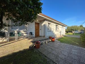 ein kleines weißes Haus mit einem Tisch und einer Terrasse in der Unterkunft Casa Otilia - Rural - Camino de Santiago - Arzúa in Arzúa