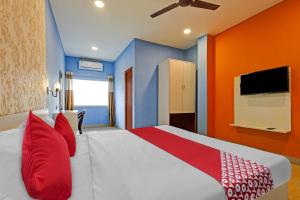 una camera con letto e pareti rosse e blu di OYO Flagship 81041 New Jebiis Inn a Kāhārpāra