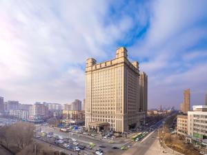 a tall building in a city with cars on a street at Hilton Garden Inn Anshan in Anshan