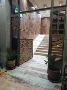 un couloir avec des plantes en pot dans un bâtiment dans l'établissement Les Belles Appartements Family Only, à Tanger