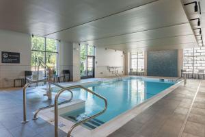 a swimming pool in a large building with a pool at Hilton Garden Inn Boston Canton, Ma in Canton