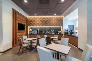 Hampton Inn by Hilton Nashville Airport Century Place في ناشفيل: مطعم بطاولات وكراسي وكاونتر