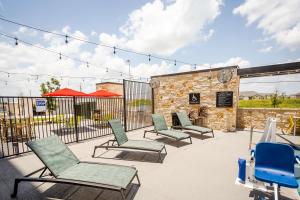 - un ensemble de chaises assises sur une terrasse dans l'établissement Home2 Suites by Hilton Pflugerville, TX, à Pflugerville