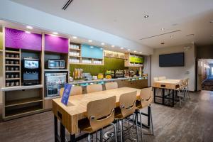 a restaurant with a table and chairs and a bar at Home2 Suites by Hilton Pflugerville, TX in Pflugerville