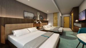 a hotel room with two beds and a television at Hilton Buena Park in Buena Park