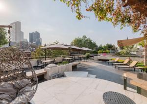 un patio con mesas, sillas y sombrillas en Lamartine 619 Residencial, en Ciudad de México