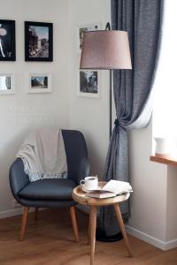 a living room with a chair and a table with a lamp at Teika No 1 Apartment in a quiet green area, self check-in in Rīga