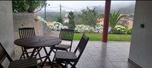 a table and four chairs with a table and a patio at Quinta Sol II Sea in Camacha