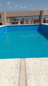 a blue swimming pool in front of a house at TORRES DEL TUCUMAN I in San Miguel de Tucumán