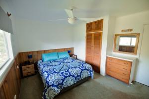 a bedroom with a bed and a dresser and a window at Cadel’s Cottage in Burnt Pine