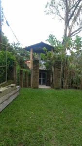 a backyard of a house with a grass yard at Pousada Rota Do Beija Flor PACOTI-CE in Pacoti