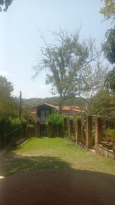 uma casa com um quintal com uma cerca em Pousada Rota Do Beija Flor PACOTI-CE em Pacoti