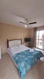 1 dormitorio con 1 cama con manta azul y blanca en Pousada Rota Do Beija Flor PACOTI-CE en Pacoti