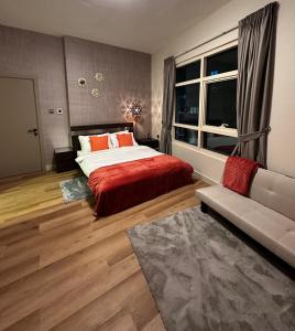 1 dormitorio con cama, ventana y sofá en smilehomesdxb, en Dubái