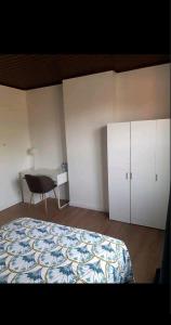 a bedroom with a bed and a desk and a chair at Room Marci- SweetHome in Marcinelle