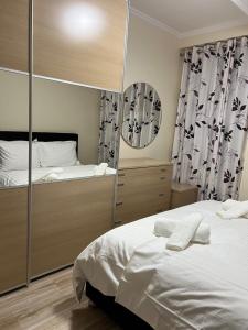 a bedroom with two beds and a mirror at Ergi’s Host Apartment in Tirana