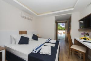 a bedroom with a bed with blue and white pillows at Amore Hotel Teki̇rova in Tekirova +32 photos