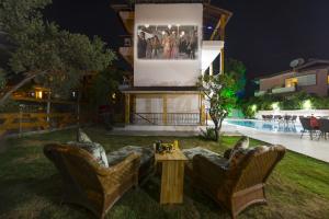 two chairs and a couch in a yard at night at Amore Hotel Teki̇rova in Tekirova