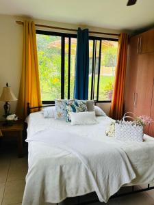 a bed in a room with a large window at Luxurious private room with bathroom in mountaine in Sorá