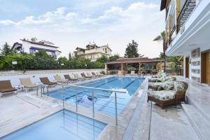 a swimming pool with lounge chairs and a hotel at Amore Hotel Teki̇rova in Tekirova