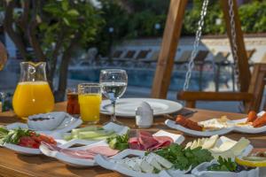 a table with plates of food and glasses of orange juice at Amore Hotel Teki̇rova in Tekirova