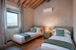 2 camas en una habitación con ventana en O:live Villa Firenze, en Lastra a Signa