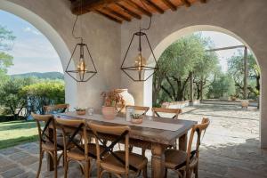 comedor con mesa de madera y sillas en O:live Villa Firenze, en Lastra a Signa