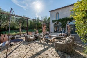 un patio con sofá, sillas y mesa en O:live Villa Firenze, en Lastra a Signa