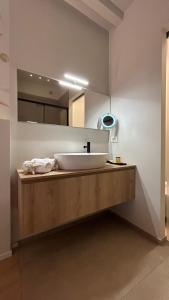 bagno con lavandino bianco e specchio di SAN LORENZO Luxury Boutique a Mantova