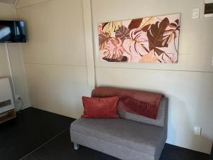 a couch with a red pillow sitting in a room at Hampshire Holiday Parks - Arrowtown in Arrowtown