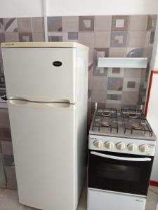 a white refrigerator and a stove in a kitchen at Apartamento amueblado en Carmelo con aire acondicionado in Carmelo