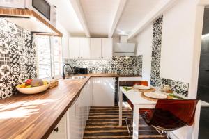 a kitchen with white cabinets and a table with chairs at Lodge Nature in quiet Montain - Private Jaccuzi and garden, Wifi - La Lézardière in San Bartolomé de Tirajana