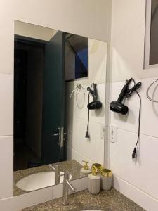 a bathroom with a mirror and a sink and a phone at AP 102-B San Pietro - Térreo in Palmas