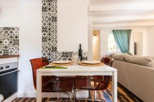 a kitchen and living room with a white table and chairs at Lodge Nature in quiet Montain - Private Jaccuzi and garden, Wifi - La Lézardière in San Bartolomé de Tirajana