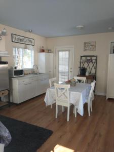 una cocina con mesa y sillas y una cocina con electrodomésticos blancos. en Sweet Boutique Suite en Langley