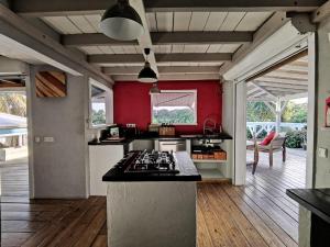 a kitchen with red walls and a stove top oven at Villa zen in Saint-François